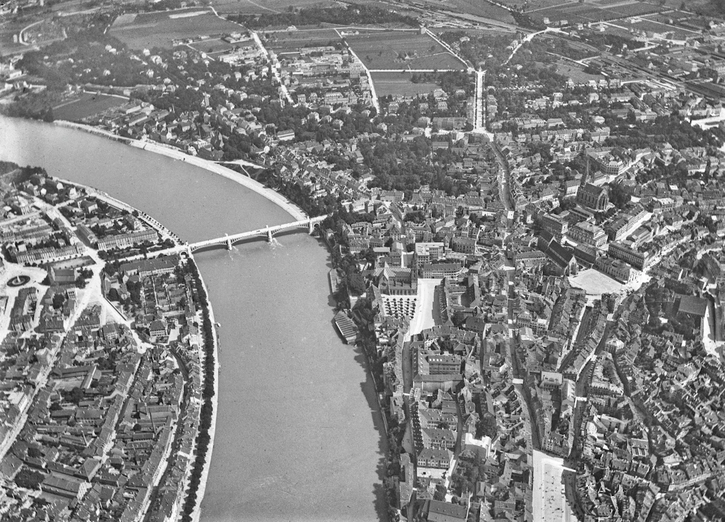 Auf dem Bild sieht man eine Luftaufnahme von Basel mit dem Rhein, welche Eduard Spelterini im Zeitraum zwischen 1893 bis 1924 aufgenommen hat.