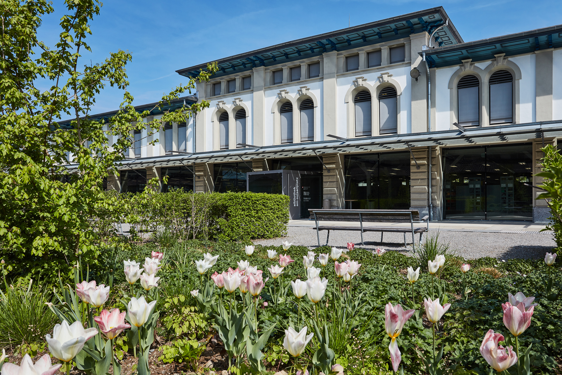 Die Bibliothek am Guisanplatz mit blühenden Blumen im Vordergrund