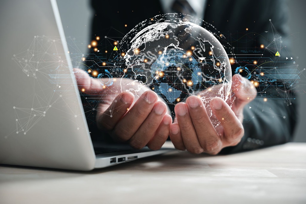 Auf dem Bild hält eine Hand einen digitalen Globus in der Hand.